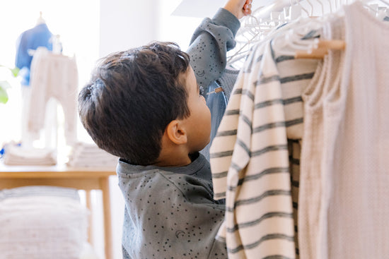 A boy choosing a shirt from a rack at francis henri